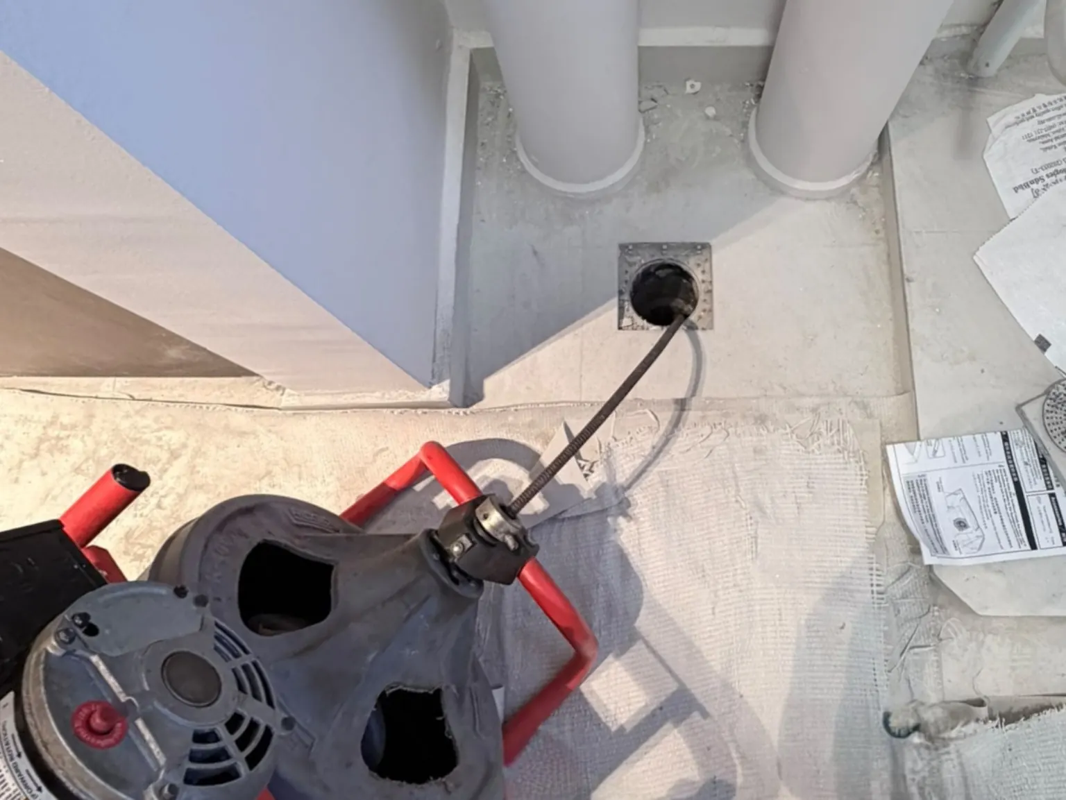 Floor trap drain choke clearing with drain cleaning equipment